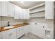 Well-organized laundry room featuring white cabinets, wood countertop, tile flooring and ample storage shelves at 942 Fairfield, Marietta, GA 30068
