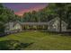 Sunset view of a charming home with a sprawling front porch, well-manicured lawn, and multiple car garage at 1031 Bailey Rd, Woodstock, GA 30188