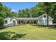Charming white home with a lush front lawn, a welcoming porch, and an attached three-car garage at 1031 Bailey Rd, Woodstock, GA 30188