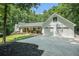 Three car garage and driveway on modern white home with welcoming front porch in lush green setting at 1031 Bailey Rd, Woodstock, GA 30188