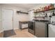 Well-organized laundry room with wooden shelves, front-loading washer and dryer, folding table, and a convenient sliding barn door at 1031 Bailey Rd, Woodstock, GA 30188
