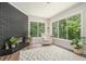 Inviting living room with a black brick fireplace, large windows offering lush green views, and comfortable furnishings at 1031 Bailey Rd, Woodstock, GA 30188