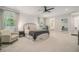 Airy main bedroom with a comfortable seating area, large windows, and a glimpse into the ensuite bathroom, all in calming neutral tones at 1031 Bailey Rd, Woodstock, GA 30188