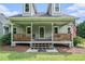 Inviting front porch with wood railing, front door with decorative glass, and classic American flag at 225 W Union Grove Cir, Auburn, GA 30011