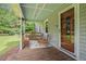 Charming front porch featuring wood floors, classic seating, and a decorative front door with glass at 225 W Union Grove Cir, Auburn, GA 30011