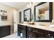 Modern bathroom with double vanity, dark wood cabinets, and excellent lighting at 242 Sandhurst Ct, Suwanee, GA 30024