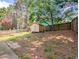 Fenced backyard with storage shed and partially overgrown grass and some trees at 2918 Pavia Circle, Austell, GA 30106