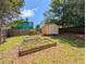 Fenced backyard with storage shed and partially overgrown grass and garden boxes at 2918 Pavia Circle, Austell, GA 30106