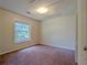 A bedroom with neutral paint, a large window, a ceiling light and a door at 2918 Pavia Circle, Austell, GA 30106