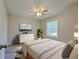 A staged bedroom with a ceiling fan, a large window and a dresser with a painting above at 2918 Pavia Circle, Austell, GA 30106