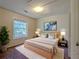 A staged bedroom with a ceiling light, a large window and a blue abstract painting at 2918 Pavia Circle, Austell, GA 30106