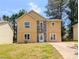 Two-story home featuring a stone facade, yellow siding, a green lawn and a concrete driveway at 2918 Pavia Circle, Austell, GA 30106