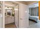 An open doorway connects the main bedroom to a bathroom featuring light fixtures and granite countertops at 3040 Peachtree Nw Rd # 1013, Atlanta, GA 30305