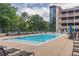 An outdoor swimming pool surrounded by lounge chairs and landscaping at 3040 Peachtree Nw Rd # 1013, Atlanta, GA 30305