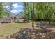 Wide backyard with mature trees and a storage shed; swimming pool is covered at 4038 Sharon Woods Dr, Powder Springs, GA 30127