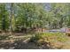 Scenic backyard showcasing a pool and deck, surrounded by lush greenery and a privacy fence at 4038 Sharon Woods Dr, Powder Springs, GA 30127
