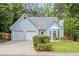 Charming light blue home with a two-car garage and landscaped front yard, blending suburban charm with curb appeal at 4038 Sharon Woods Dr, Powder Springs, GA 30127