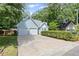 An inviting light blue home featuring a spacious driveway leading to a two-car garage, framed by mature trees at 4038 Sharon Woods Dr, Powder Springs, GA 30127