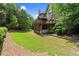 Wide shot of backyard with a two-story deck, and lush green lawn at 4955 Winding Rose Dr, Suwanee, GA 30024