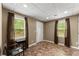 Finished basement with tiled floor, two windows, and a chair at 4955 Winding Rose Dr, Suwanee, GA 30024