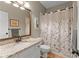 Bathroom featuring a granite vanity, a toilet and a bathtub with a floral shower curtain at 4955 Winding Rose Dr, Suwanee, GA 30024