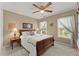 Cozy bedroom featuring carpet, ceiling fan, window, side table with lamp, and wood headboard at 4955 Winding Rose Dr, Suwanee, GA 30024
