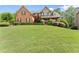 Attractive brick home with a green lawn and sculpted bushes enhancing the property's aesthetic appeal at 4955 Winding Rose Dr, Suwanee, GA 30024