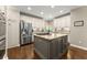 Elegant kitchen with ample storage, stainless steel appliances, and a gray island with granite countertops at 4955 Winding Rose Dr, Suwanee, GA 30024