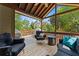 Relaxing covered porch with comfortable seating and a wooded view at 4955 Winding Rose Dr, Suwanee, GA 30024