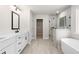 Bright bathroom with double vanity, soaking tub, glass shower and tile floors at 910 Melody Ridge Ln, Buford, GA 30518