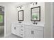 Well-lit bathroom boasts a double vanity with quartz countertop, black hardware, and two framed mirrors at 910 Melody Ridge Ln, Buford, GA 30518