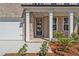 Elegant entryway featuring a black front door with sidelights, framed by white columns and professional landscaping at 910 Melody Ridge Ln, Buford, GA 30518