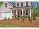 Charming front of a brick home with a welcoming covered porch and beautifully maintained landscaping at 910 Melody Ridge Ln, Buford, GA 30518