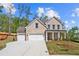 Stunning two-story brick home featuring a three-car garage, manicured lawn, and classic architectural details at 910 Melody Ridge Ln, Buford, GA 30518