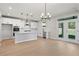Expansive white kitchen with a large island, stainless steel appliances, and an adjacent dining area with outdoor access at 910 Melody Ridge Ln, Buford, GA 30518