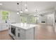 Bright kitchen with an island, stainless steel microwave, pendant lights, and a view of the backyard at 910 Melody Ridge Ln, Buford, GA 30518