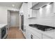 Close-up of a modern kitchen with sleek white cabinetry, stainless steel appliances, and stylish hardware at 910 Melody Ridge Ln, Buford, GA 30518