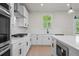 Gourmet kitchen featuring white cabinets, stainless steel appliances, gas range, and modern finishes at 910 Melody Ridge Ln, Buford, GA 30518