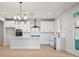 Bright, open-concept kitchen boasts white cabinetry, a central island, and modern fixtures, perfect for entertaining at 910 Melody Ridge Ln, Buford, GA 30518