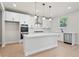 Well-appointed kitchen with white cabinets, quartz countertops, stainless steel appliances, and hardwood floors at 910 Melody Ridge Ln, Buford, GA 30518