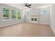Bright living room with a cozy fireplace, hardwood flooring, and many large windows with a view of the outdoors at 910 Melody Ridge Ln, Buford, GA 30518