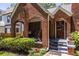 Cozy front porch seating area with brick arches and views of the beautifully landscaped yard at 1055 Woodland Se Ave, Atlanta, GA 30316