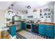 Bright kitchen featuring teal cabinets, stainless steel appliances, and barstool seating at 1055 Woodland Se Ave, Atlanta, GA 30316