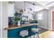 Open kitchen with teal island seating, stainless appliances, and view into dining area at 1055 Woodland Se Ave, Atlanta, GA 30316
