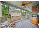 Relaxing covered back porch featuring rocking chairs, ceiling fan, and a unique barrel TV stand at 177 Coopers Pond Dr, Lawrenceville, GA 30044