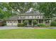Charming two-story home with a large covered front porch, mature trees, and attached two-car garage at 177 Coopers Pond Dr, Lawrenceville, GA 30044