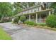 A view of the home's exterior, featuring a large porch, mature landscaping and a circular driveway at 177 Coopers Pond Dr, Lawrenceville, GA 30044