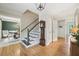Welcoming foyer with hardwood floors, staircase, grandfather clock, and open dining area at 177 Coopers Pond Dr, Lawrenceville, GA 30044