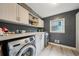 Efficient laundry room with front-load machines, ample counter space, storage and large window at 177 Coopers Pond Dr, Lawrenceville, GA 30044