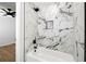 Modern bathroom showcases a luxurious shower with elegant white marble tiling and sleek black hardware at 5115 Leland Dr, Stone Mountain, GA 30083